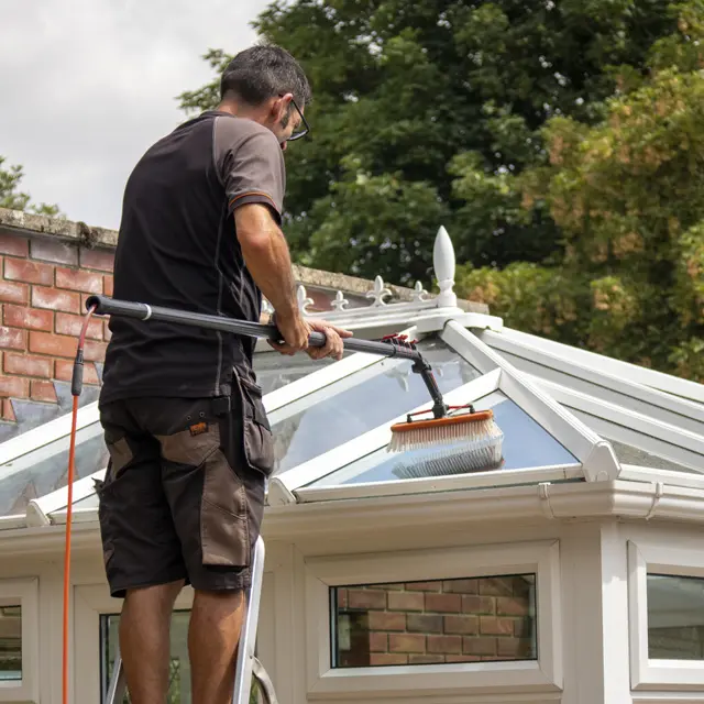 Crystal Clean Windows technician using a reach-and-wash system to clean a white conservatory roof in Parson Drove, Wisbech.