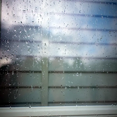 Raindrops on a clean window pane, illustrating that professional pure water window cleaning is effective even in rainy weather.